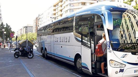 Un viajero se sube a uno de los autobuses de la compañía La Unión que para en la avenida de Gasteiz