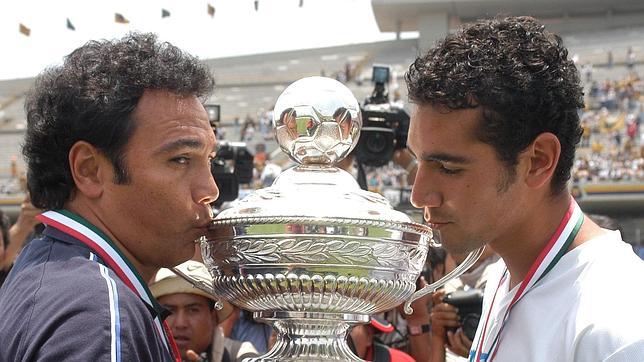 Hugo Sánchez y su hijo posan con un trofeo conquistado con los Pumas mexicanos, de los que el padre era entrenador y el hijo jugador.