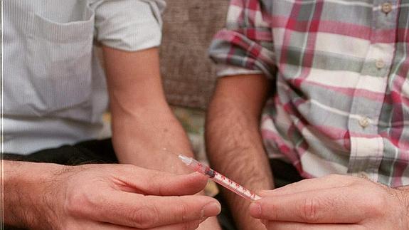 Foto de archivo en la que dos toxicómanos comparten una jeringuilla.