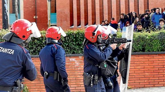 Un ertzaina apunta con la nueva escopeta, que lanza proyectiles de caucho en vez de las clásicas pelotas de goma, durante los graves altercados el jueves en Vitoria.