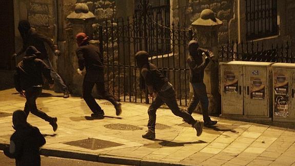 El grupo de encapuchados lanza objetos a la Policía en el Casco Viejo. 