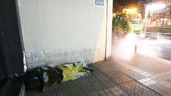 Una persona sin hogar duerme a la intemperie en una calle de Bilbao. 