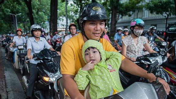 El uso generalizado del casco contrasta con la ausencia de semáforos y la presencia de niños sin protección. 