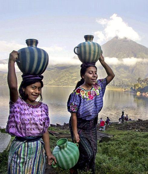 Dos indígenas llevan agua del lago Atitlán. 