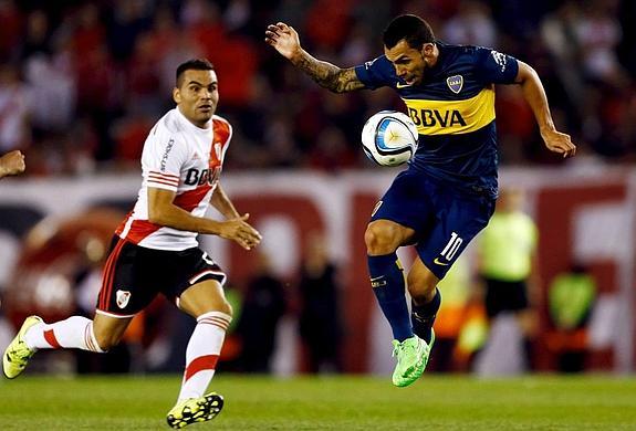 Carlos Tévez, del Boca, controla el balón bajo la mirada del jugador del River Gabriel Mercado.