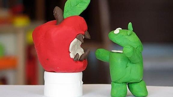 Una manzana mordida y un robot verde, los símbolos del iOS de Apple y el Android de Google. 