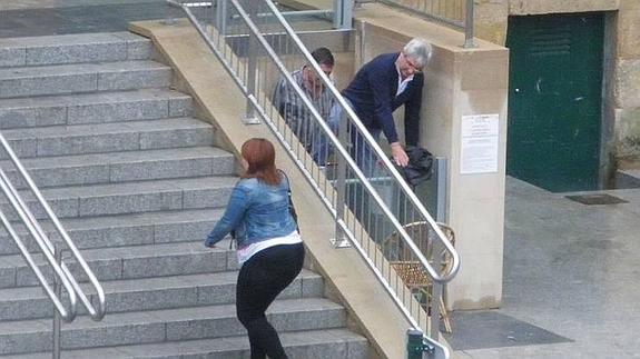 Dos personas intentan salir del elevador tras quedar atrapados. 