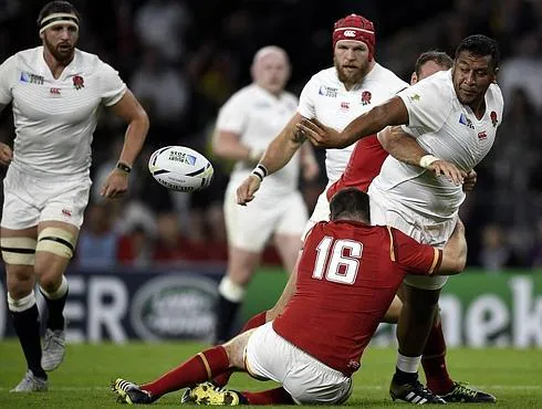 Un must, el pilar inglés de origen neozelandés Mako Vunipola (130 kilos) da un pase 'a la remanguillé' tras ser placado por dos galeses.