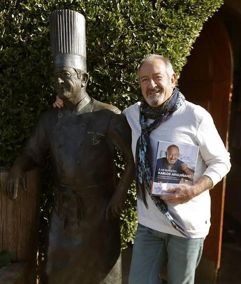 Karlos Arguiñano junto a una estatua que le representa y con la que se fotografían los visitantes.