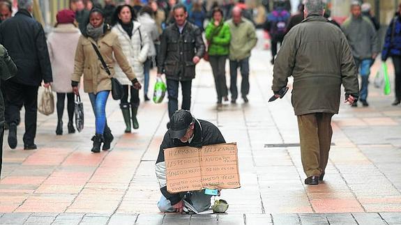 Un hombre pide dinero en una calle en el centro de Vitoria. 