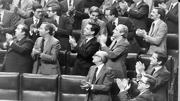 Imagen de 1978: Adolfo Suárez, presidente del Gobierno, Manuel Gutiérrez Mellado, vicepresidente; ministros y diputados aplauden después de aprobarse el proyecto constitucional en el Congreso.