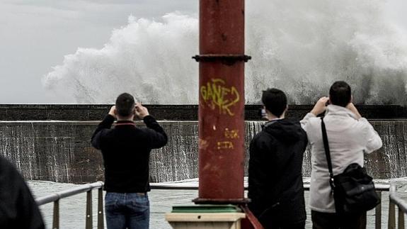 Varios vecinos fotografían el oleaje en Plentzia.