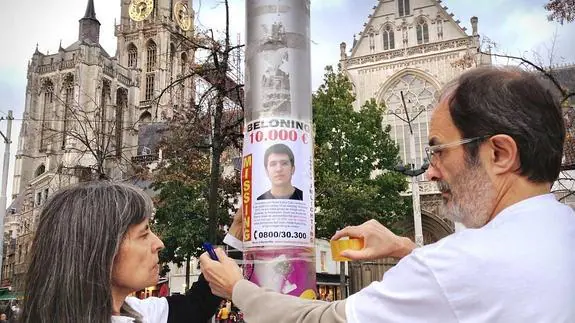 Koro Díaz y Pablo Egiluz pegan un cartel con el rostro de Hodei en Amberes.