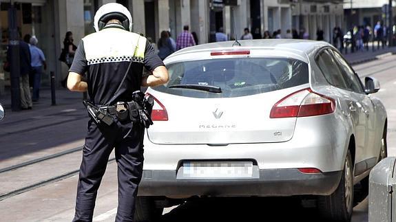 Un agente multa a un vehículo mal estacionado en Vitoria.  