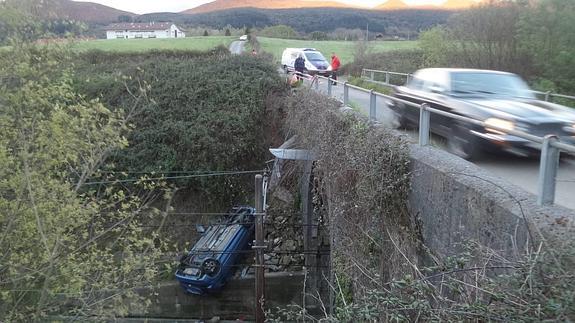 Así ha quedado el vehículo, volcado en la vía ferroviaria.