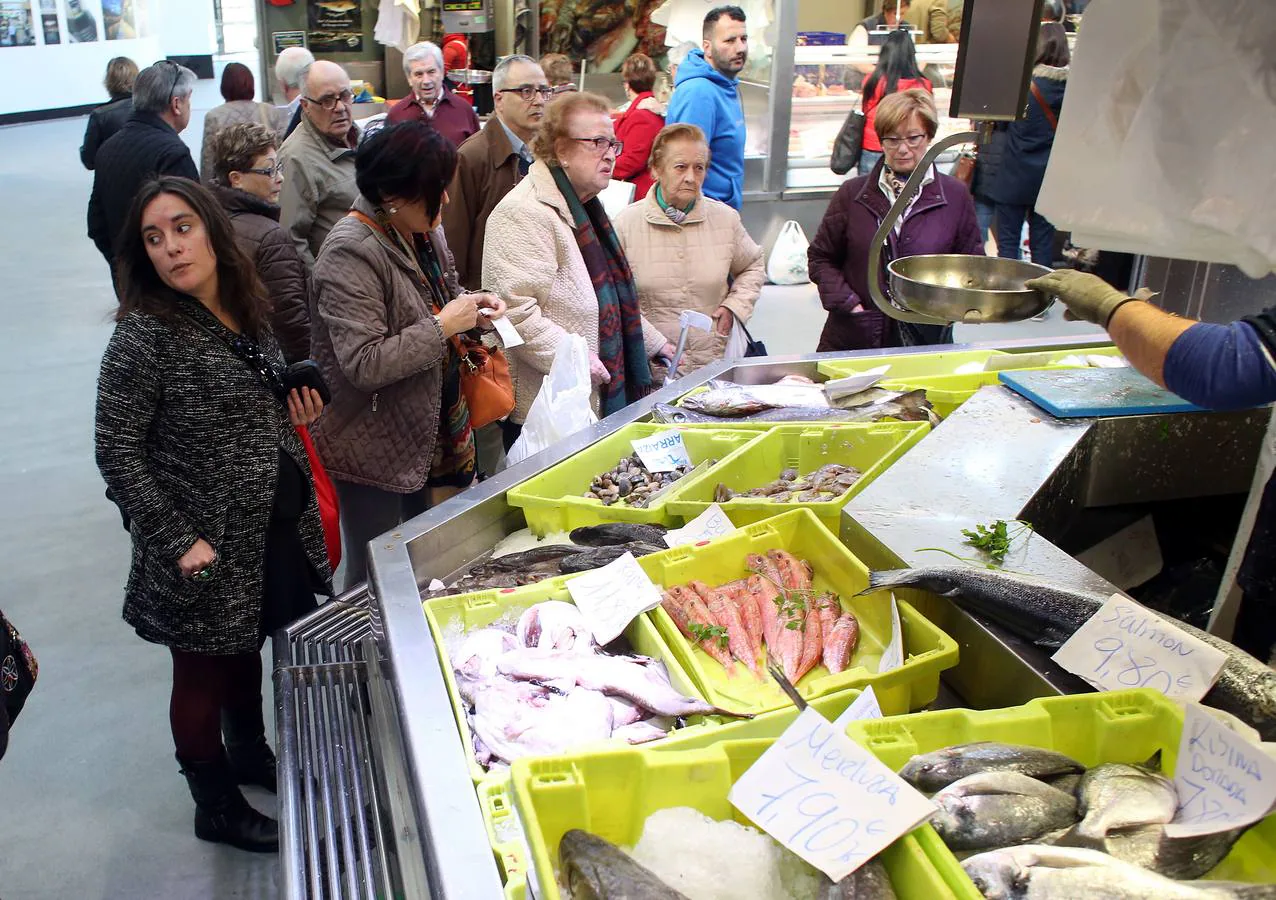 Varios clientes en una pescadería del Mercado de la Ribera.