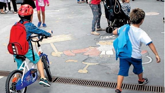 Dos niños llegan al colegio Zabalgana en bici y a pie.