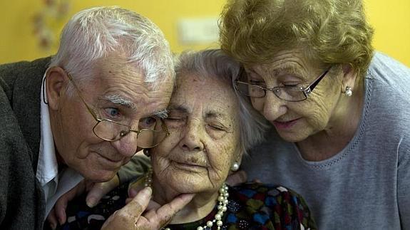 Ana Vela, de 114 años, posa junto a sus dos hijos.