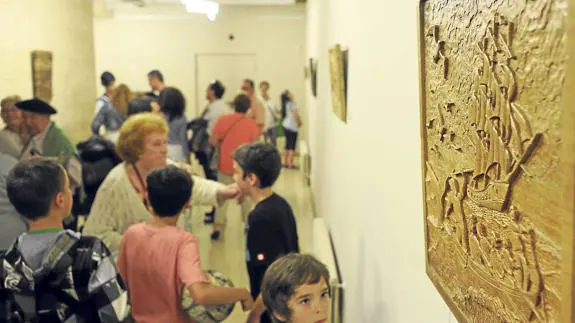 Un niño contempla una de las piezas talladas por García del Monte