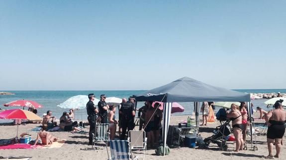 Agentes de la Policía Local en la playa de Pedregalejo interrogan a los bañistas para dilucidar qué sucedió con el fardo de hachís.