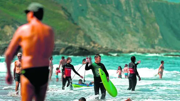 Bañistas tradicionales, paseantes y deportistas comparten actividades en el arenal de Sopela el pasado viernes