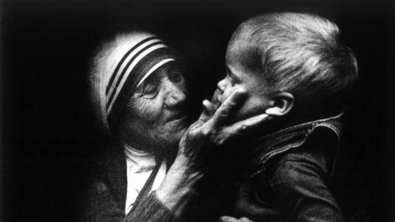 La madre Teresa de Calcuta acaricia a un niño durante una visita a Polonia.