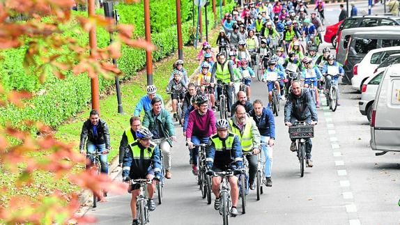 Ciudadanos y concejales participan en una marcha ciclista escolar durante el día sin coches. 