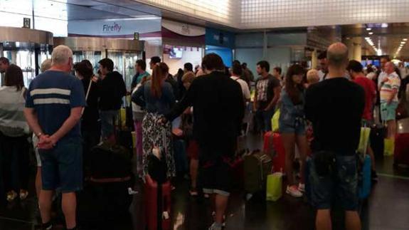 Pasajeros esperan a recibir algún tipo de información en el aeropuerto de El Prat.