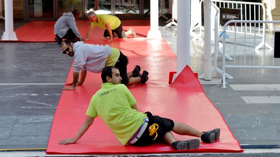 Varios operarios colocan la alfombra roja.