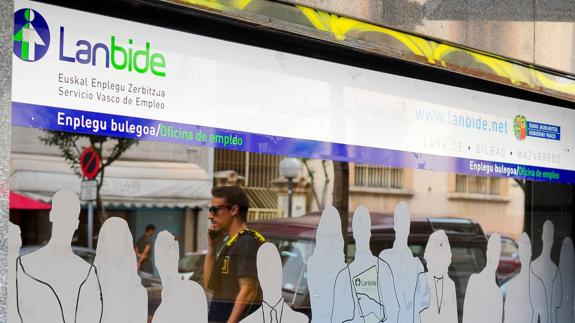 Un hombre camina junto a una oficina de Lanbide.