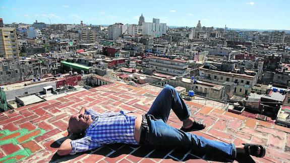 Pedro Juan Gutiérrez, gran cronista literario de La Habana, descansa en su terraza, desde la que se divisa una espectacular vista de la capital cubana.