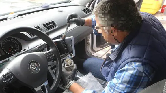 Un policía recoge evidencias en un coche al que han robado la consola en Getxo. 