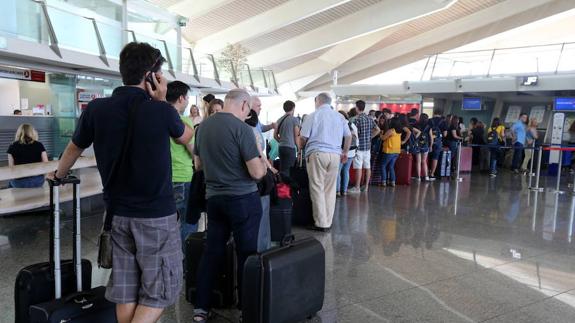 Pasajeros en el aeropuerto de Loiu esperan para facturar sus maletas.