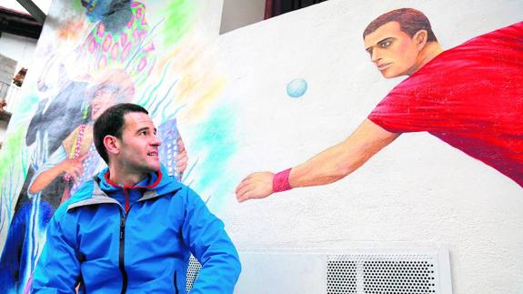 El zaguero de Leitza observa una pintura de un pelotari a punto de golpear una pelota ubicada en el centro de su localidad.