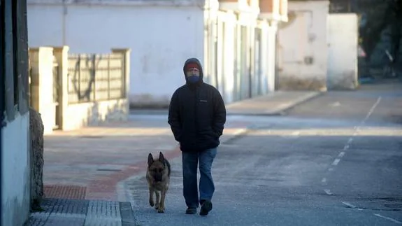 Un hombre, con su perro por Otxandio el domingo por la mañana.