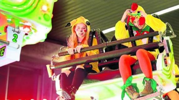 Dos niños disfrutan de una de las atracciones instaladas en los pabellones de la feria de Ansio.