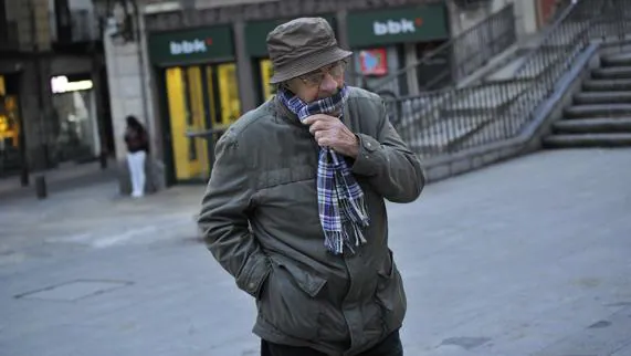 Un hombre se protege del frío en Bilbao esta mañana.