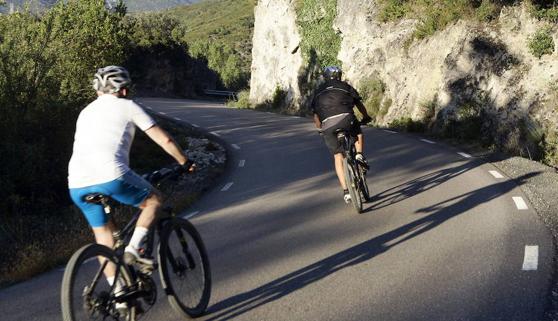 Dos cicloturistas circulan por un vía.