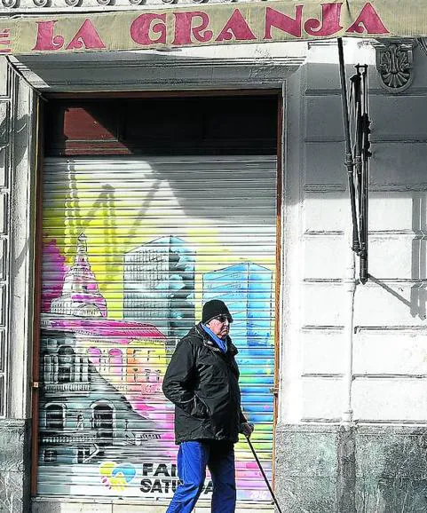 Un hombre pasea junto a La Granja, cerrado el miércoles.