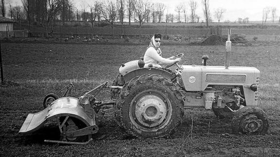 Una mujer conduce un tractor en la década de los 60.