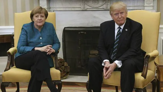 Incómodo momento en el que Merkel le ofrece la mano y Trump ignora el ofrecimiento delante de los fotógrafos.