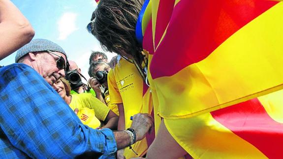 Lluís Llach, diputado de Junts pel Sí en el Parlamento catalán, firma autógrafos durante la Diada de 2013.