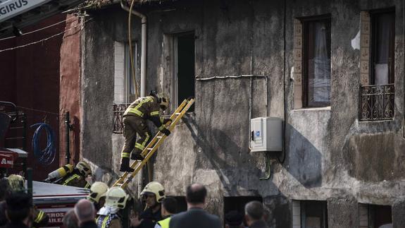 Un bombero trata de acceder al edificio quemado. 