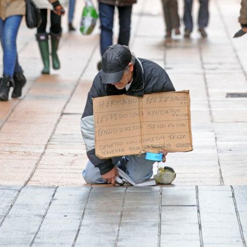 Un hombre pide en una céntrica calle de Vitoria.