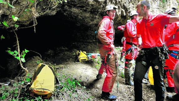 Miembros del grupo de rescate se preparan para bajar a la cueva.