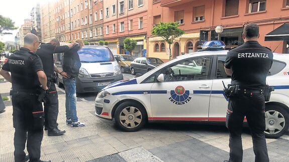 Agentes de la Ertzaintza cachean a un sospechoso en una calle de Vitoria.