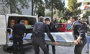 Trabajadores de la funeraria trasladan el cuerpo de la mujer de 62 años./EFE