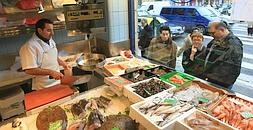 Clientes mirando el género de una pescadería