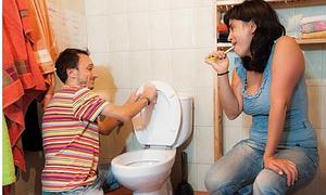 Un hombre limpia un retrete mientras su pareja se lava los dientes. Foto de Guillermo Casas que el colectivo Piper Txuriak ha incluido en su calendario 2013