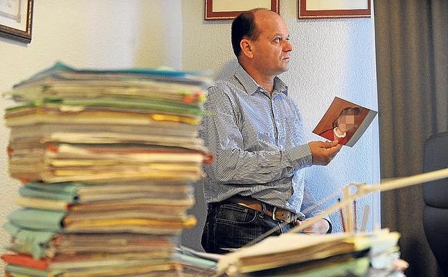 Fernando Oliveira sujeta una foto de su hija en el despacho de su abogada en Bilbao. / Borja Agudo